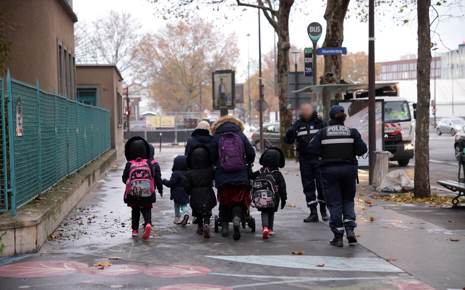 Children walk to school with police escort in Paris because of a rise in drug addicts and prostitution
